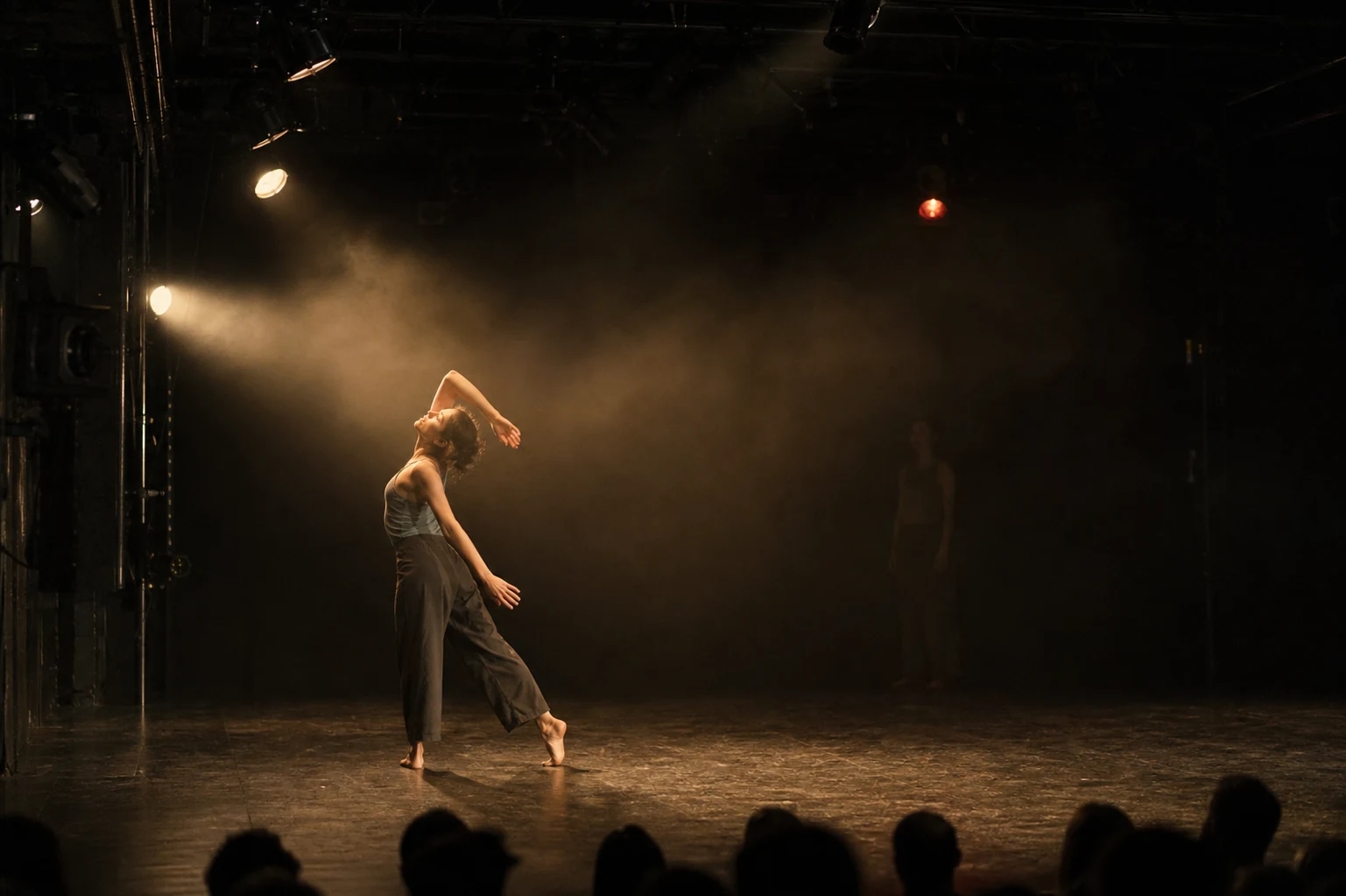 Een moderne danser gevangen in een precieze warme bundel op een intiem podium
